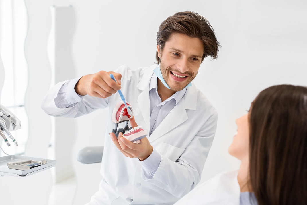 Doctor showing a patient how to care for their oral health